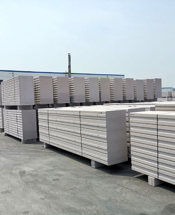 "Industrial ALC panels stacked in warehouse - precast autoclaved lightweight concrete wall elements"