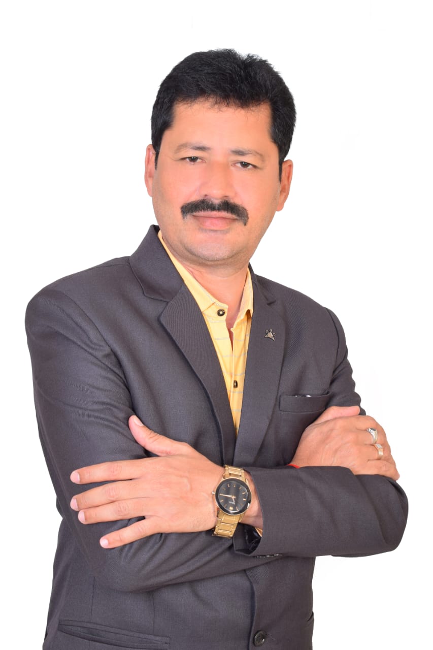 "Professional businessman in dark grey suit with yellow shirt standing confidently with crossed arms wearing gold watch"